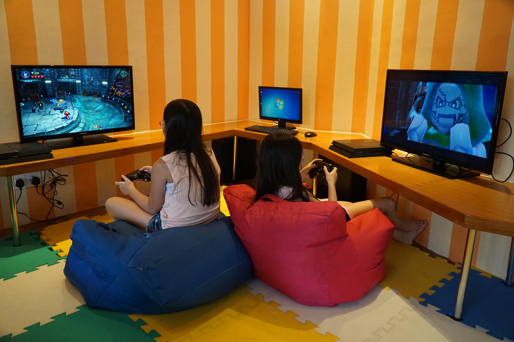 Kids have fun activities by playing PlayStation at a beach resort in Nusa Dua